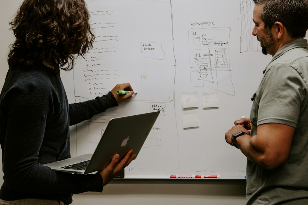 Twee collega's die een plan uittekenen op een whiteboard
