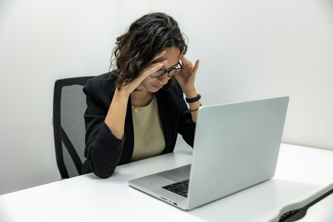 Medewerker die zuchtend naar haar laptop kijkt